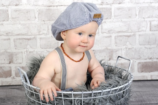 Baby mit Mütze und Hosenträger