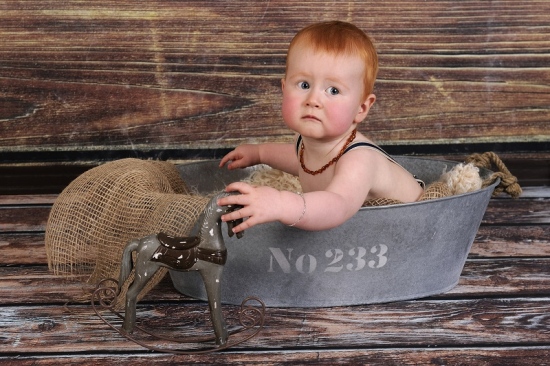 Rothaariges Baby schaut erschreckt aus Eisenwanne