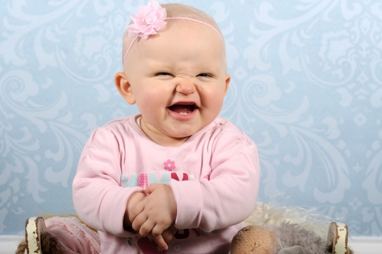 Lachendes Baby mit rosa Schleife
