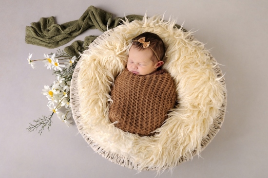 10_Fotografie-Karoart-Neugebores-in-Koerbchen-mit-gruenem-Tuch-Fell-bluemchen-Schleifchen-im-Haar-Pfaeffikon-Winterthur-Zuerich-Volketswil