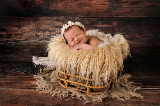 11_Fotografie-Karoart-lachendes-Neugeborenes-in-Ratankorb-Fell-und-Jutedecke-sweet-Baby-Uster-Duebendorf-Winterthur-Zuerich-Volketswil