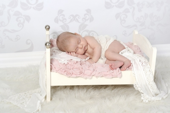 Babyfotografie eines Neugeborenen aus Schwyz in kleinem Bettchen