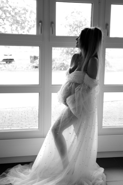 2_Fotografie-Karoart-Schwangerschaft-Neugeborene-huebsche-Schwangere-Perlenkleid-vor-dem-Fenster-Babybauch-Faellanden-Uster-Winterthur-Volketswil